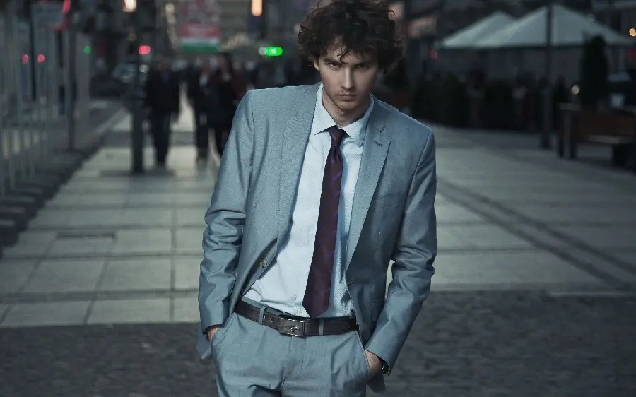 Handsome foreign male modeling in a luxurious tuxedo suit and tie