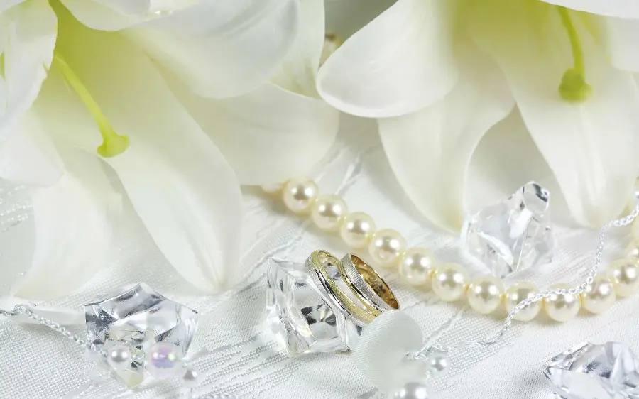 Background of a pearl necklace and diamond pieces and two beautiful rings
