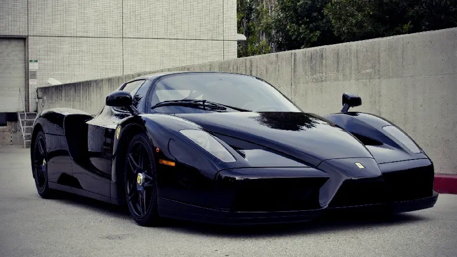 Wallpaper of a magnificent navy blue Ferrari Enzo in a parking lot