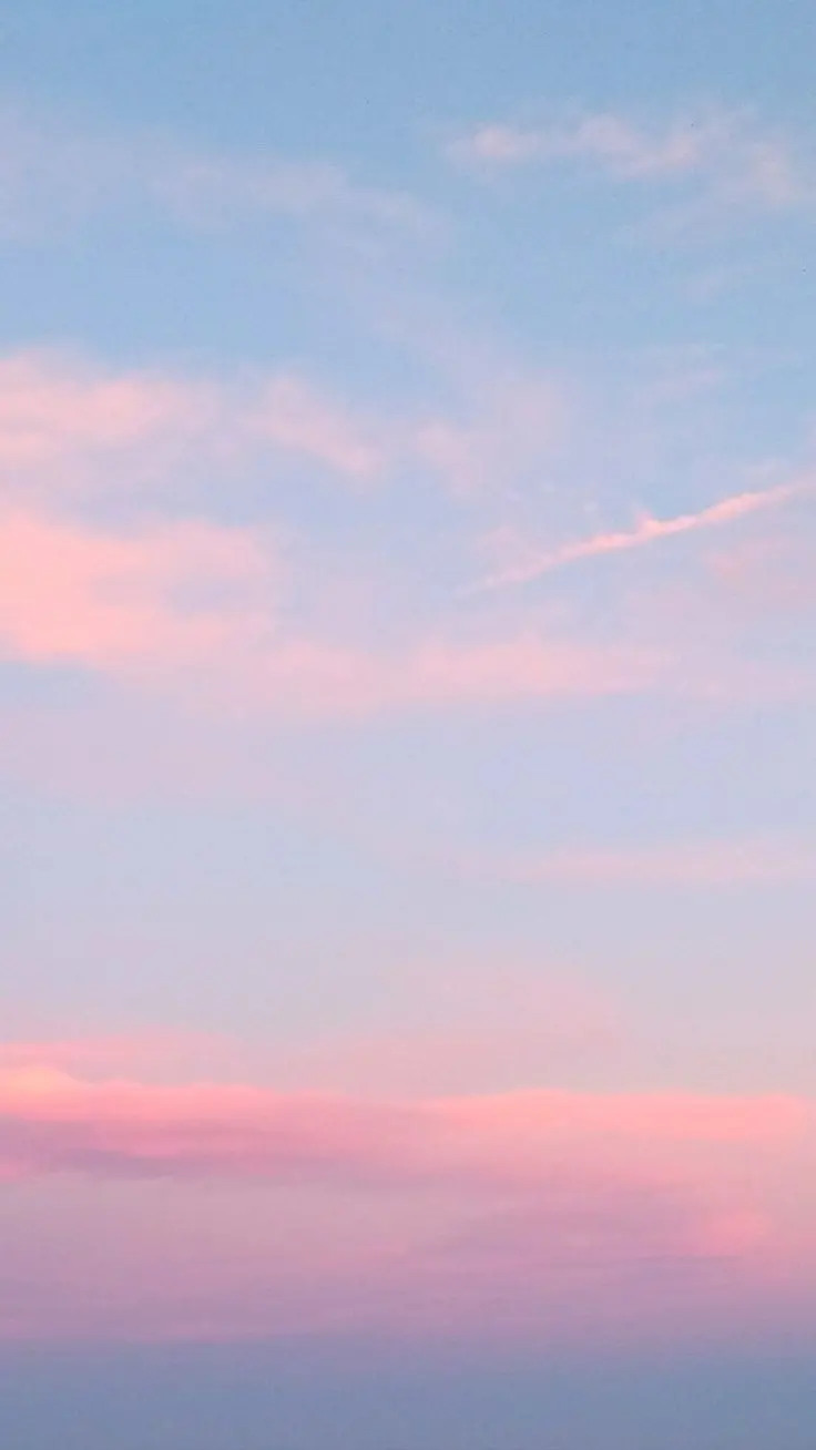 New and blurred image of a blue sky with thin pink clouds in low quality