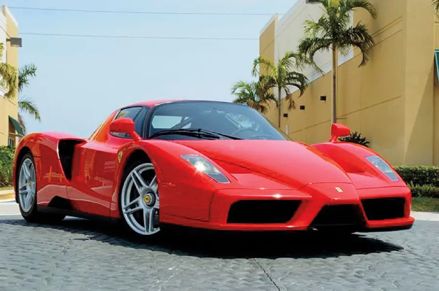 Classy photo of a neat Ferrari Enzo on a coastal road