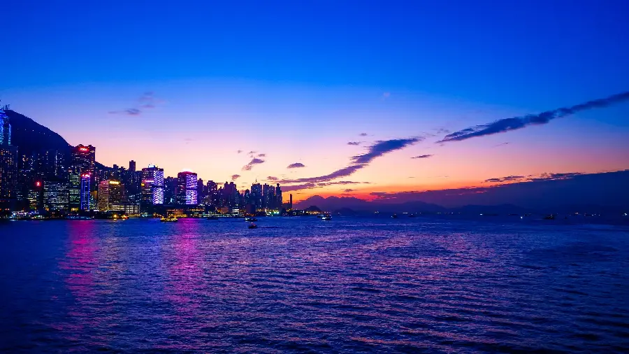 Download the background image of the sunset with the beauty of the water next to the buildings of Barcelona