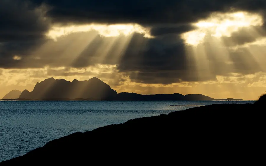 Stunning background of strong rays of sunlight through the clouds on the sea