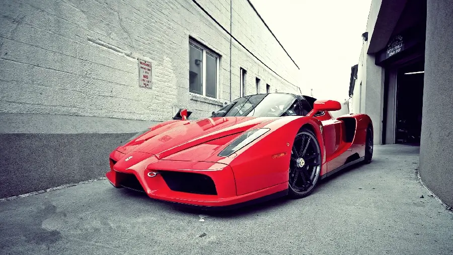 Download full quality and stock photo of a red Ferrari Enzo outside a building