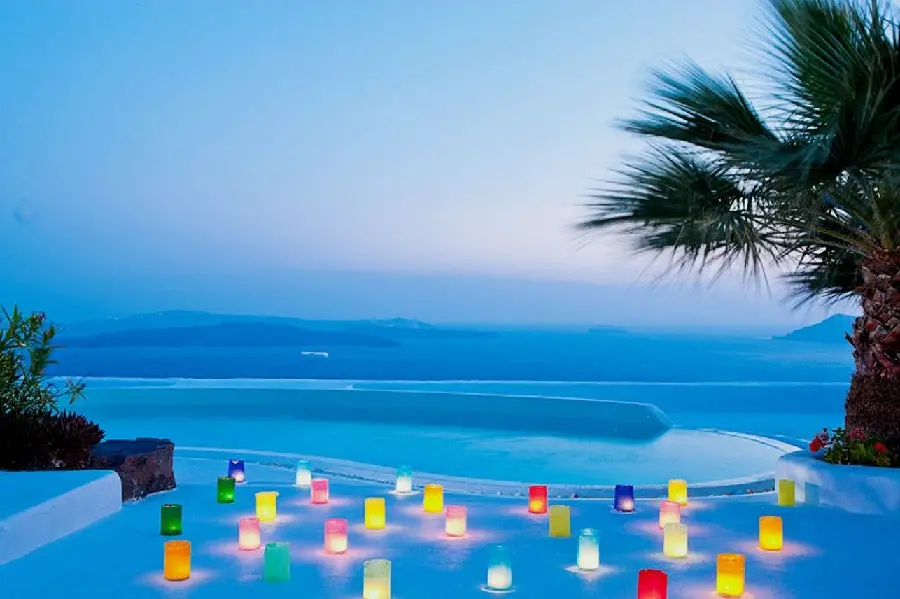 Dreamy wallpaper of colored lanterns of wishes in Santorini next to palm trees