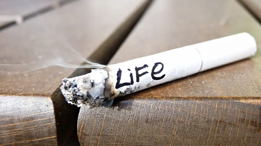 A special mobile background image of cigarette smoke with the English inscription Life on the edge of a wooden bench
