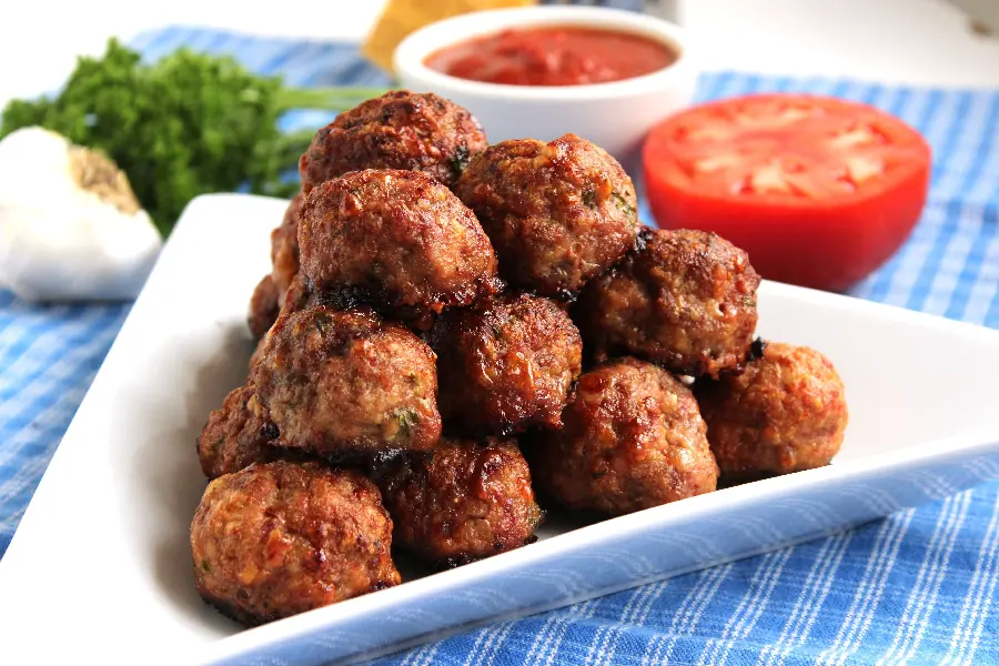 Background photo of High quality of the most popular food, meatballs, on a triangular white plate with tomato sauce and a slice of it, suitable for tablets