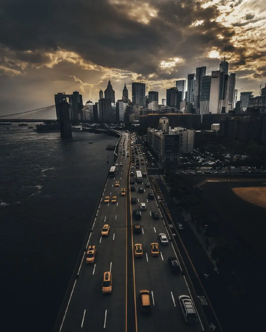 A busy and dark background image of a city road with many cars in a big city
