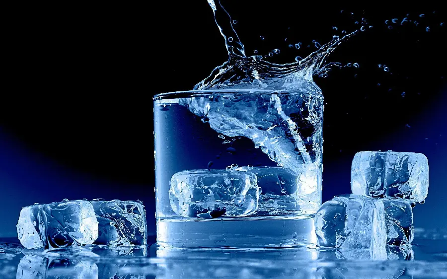 Amazing Background of a Small Glass of Drinking Water and Ice Cubes Next to It