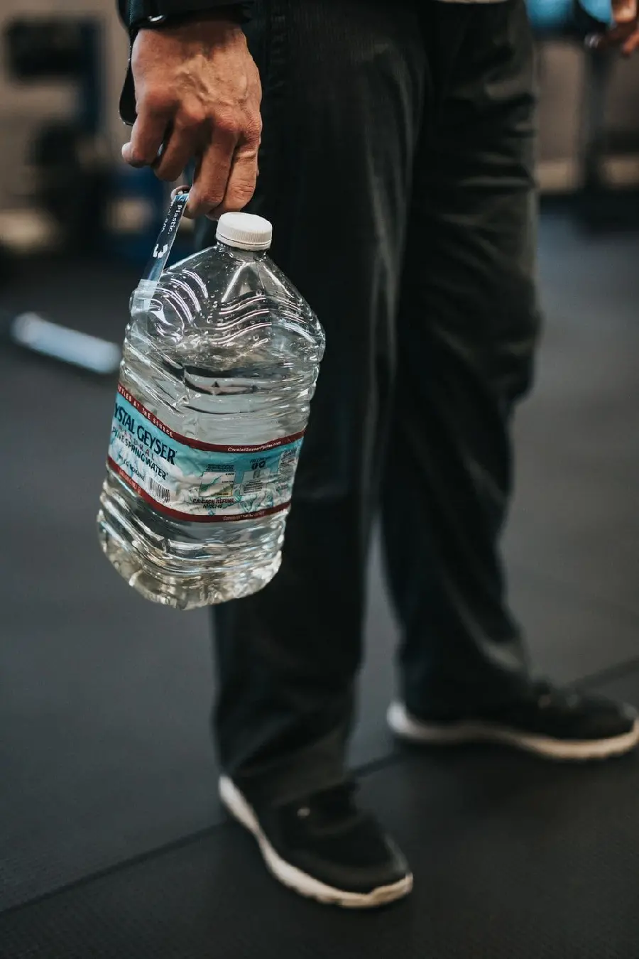 A large poster of a bottle of drinking mineral water in a man's hand