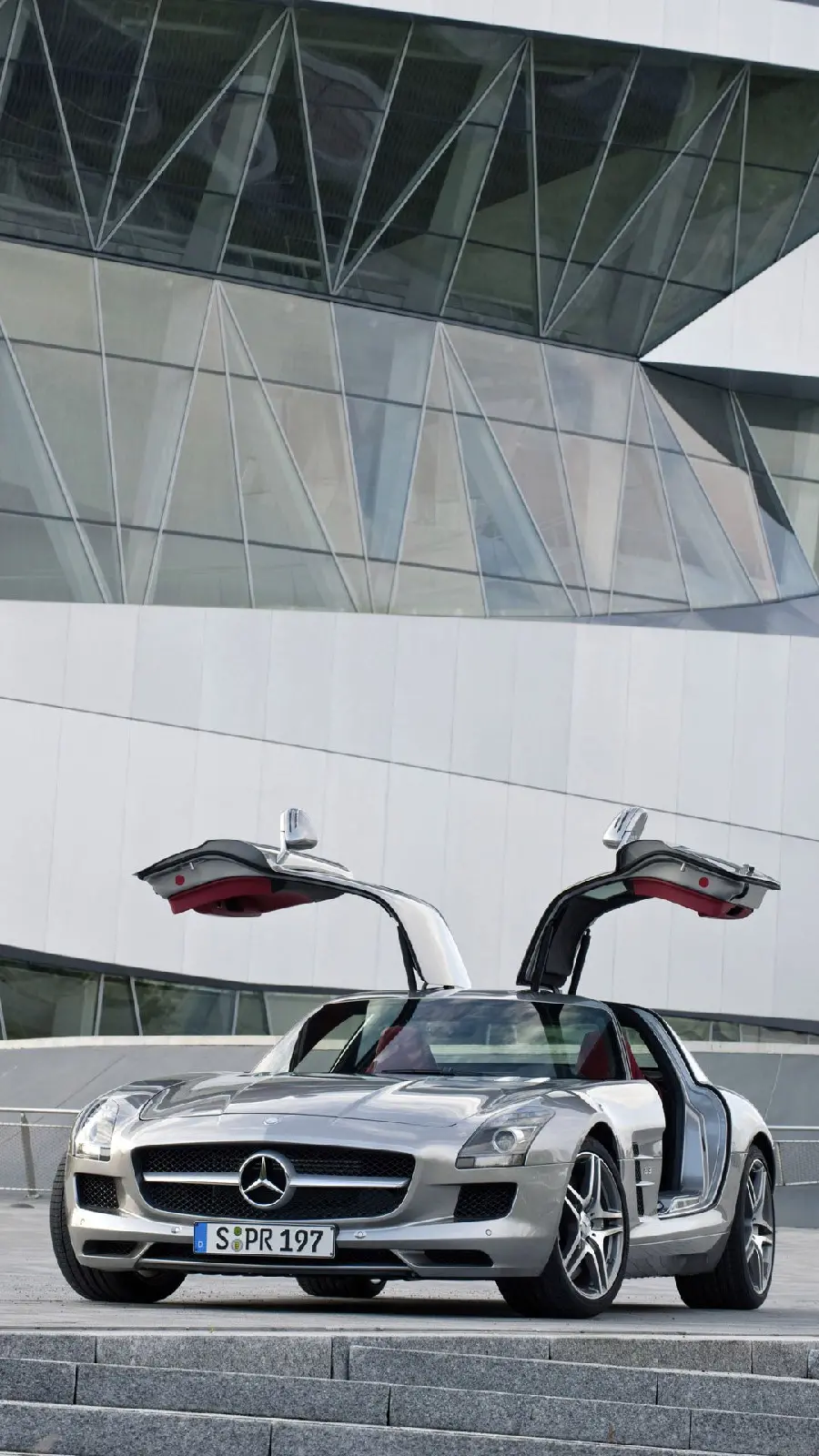 Download stock photo of a gray Mercedes-Benz Gullwing next to a glass building