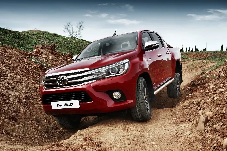 Download the latest profile photo of the red Toyota Hilux in the green plain