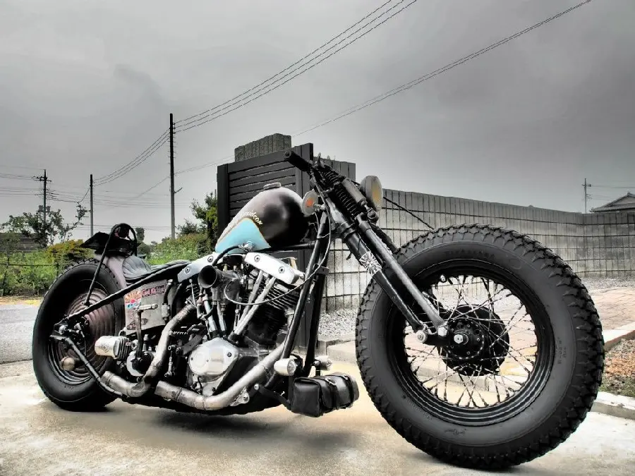 Clean stock photo of a new and heavy custom black motorcycle next to a building
