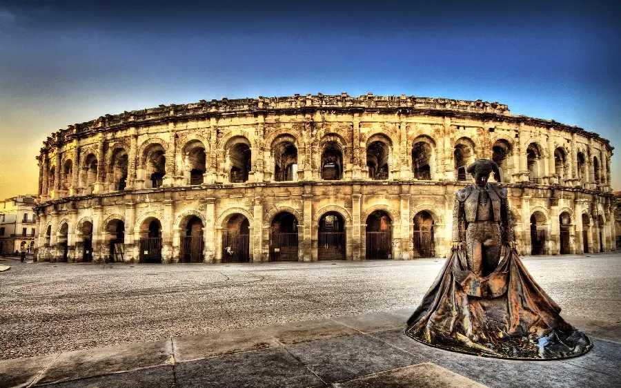 Download historical stock photo of the Colosseum built on a park building with a statue next to it