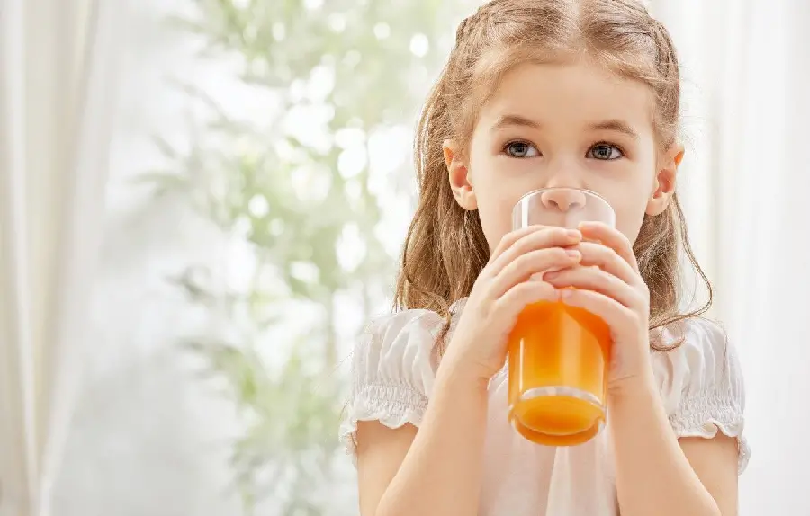 So Beautiful background of a cute little girl drinking an orange drink