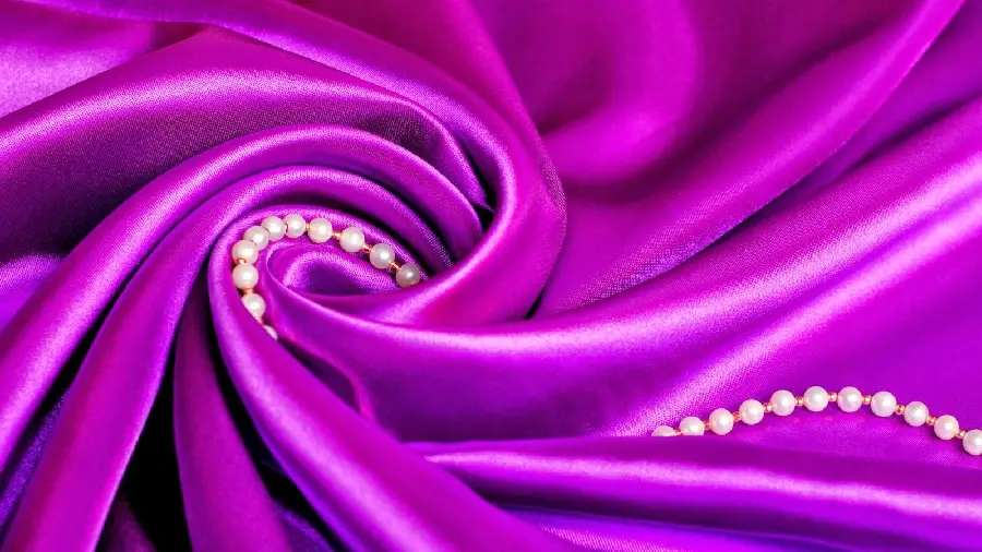 A charming background of a pearl necklace among purple lining