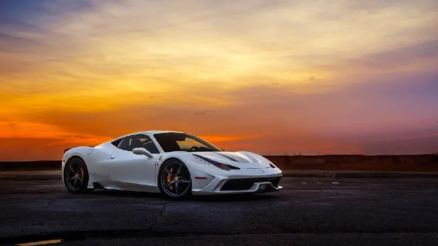 A beautiful photo of a white Ferrari with beautiful tires and rims in a golden sunset