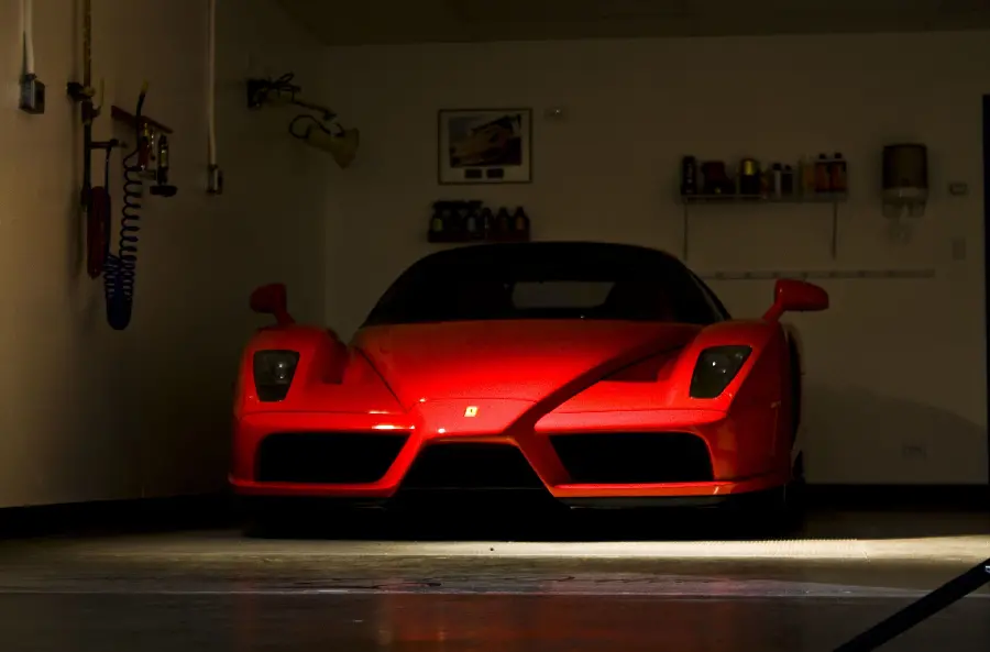 Stylish and high-class wallpaper of a red Ferrari Enzo in a dark parking lot