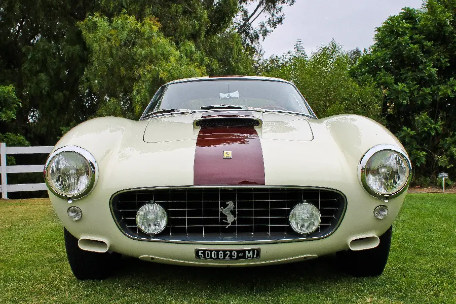 A magnificent image of a two-tone white and crimson Ferrari in clear FUII HD quality in a lush green area