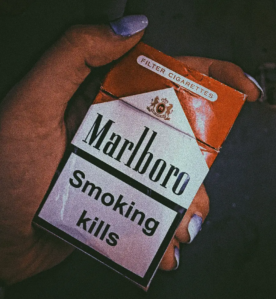 Semi-transparent image of a Marlboro Cigarette Box in the Hands of a Woman