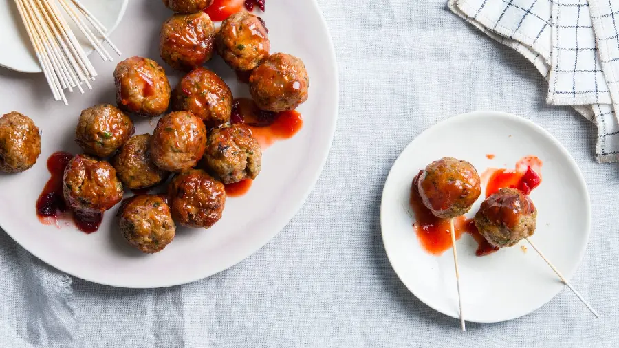 Top quality background of modern small meatball food with a little red sauce attached with a wooden skewer arranged on a white tray and plate
