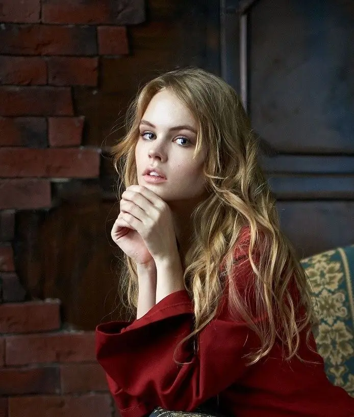 A profile photo with a beautiful and amazing pose of a Russian girl in a high-quality burgundy dress Top