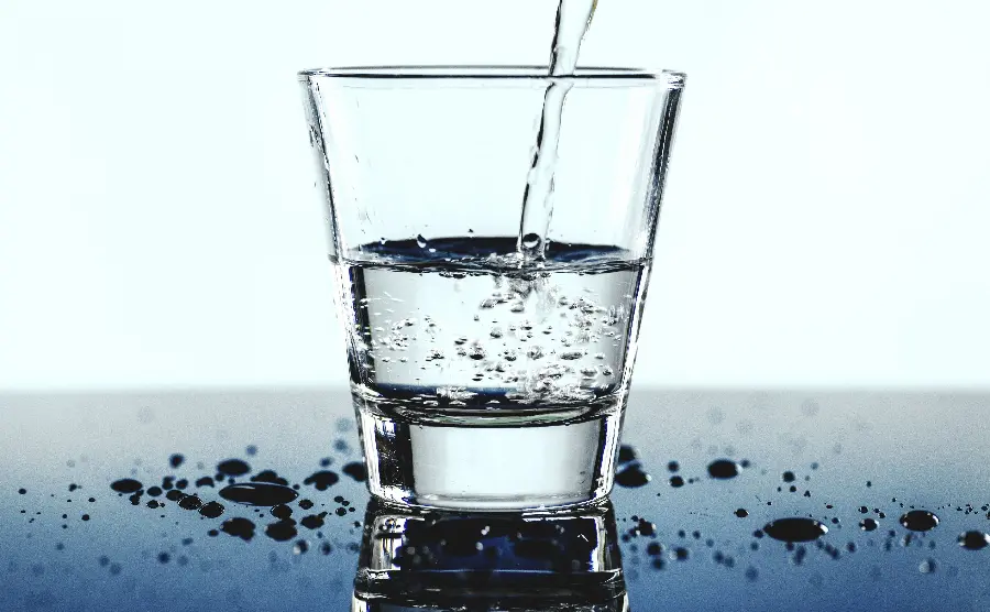 Strange image of a glass being filled with drinking water with water droplets around it