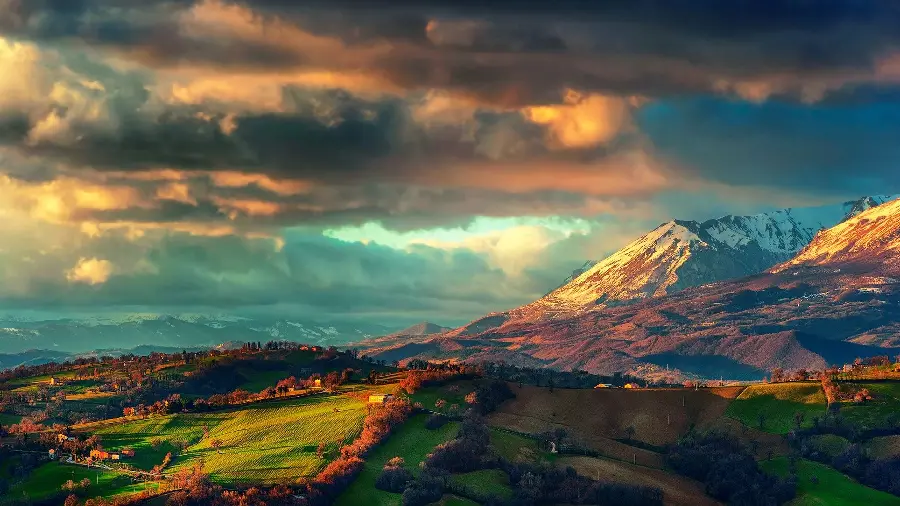 A charming image of a dreamy nature and a cloudy sky with a high snowy mountain