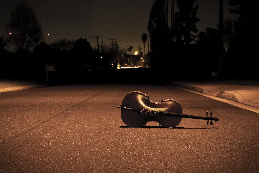 Picture of a sad violin lying on the ground on a lonely street