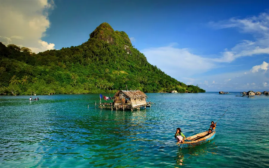 Photo of the Balinese sea with boats and native huts in the middle of it