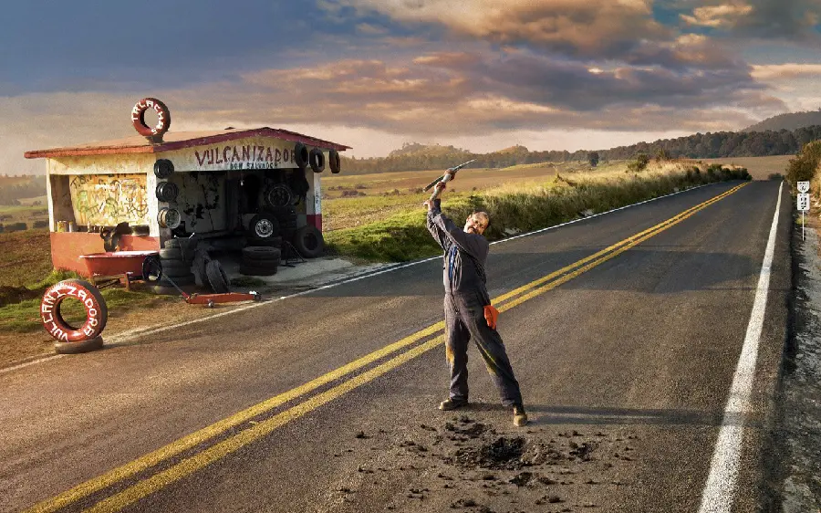 Strange and symbolic image of a roadside mechanic digging up a street