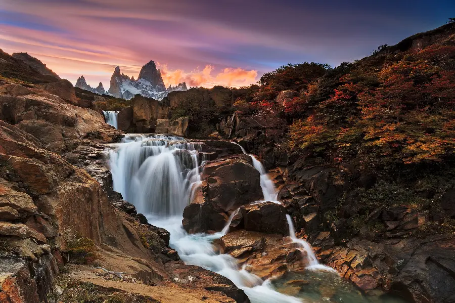 A special stock photo of a stone fountain under a colorful sunset sky