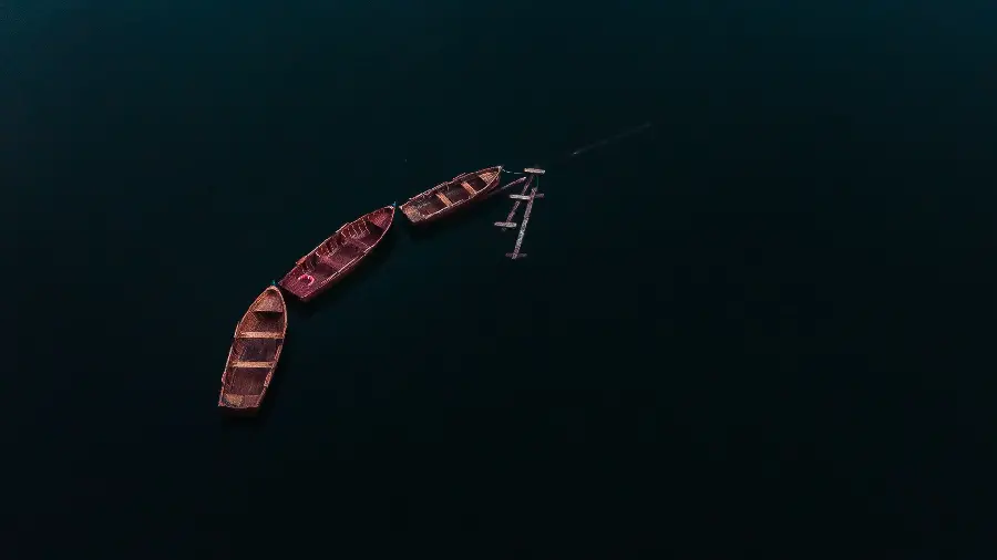 Dreamy wallpaper of wooden boats in the middle of the sea in 4K quality for desktop