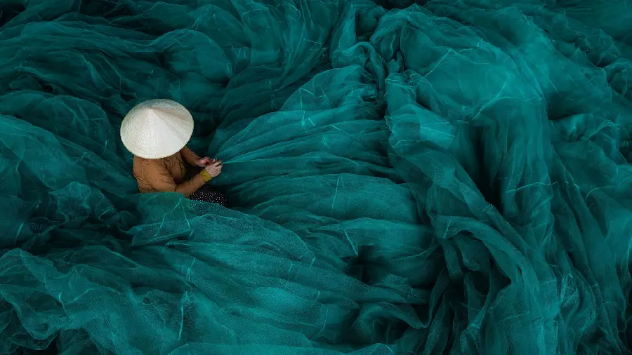 Photo Extraordinary Art of a Woman Among the Green and Blue Fabric