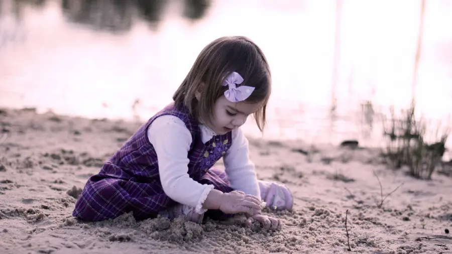 Photo of a beautiful little girl playing on the beach