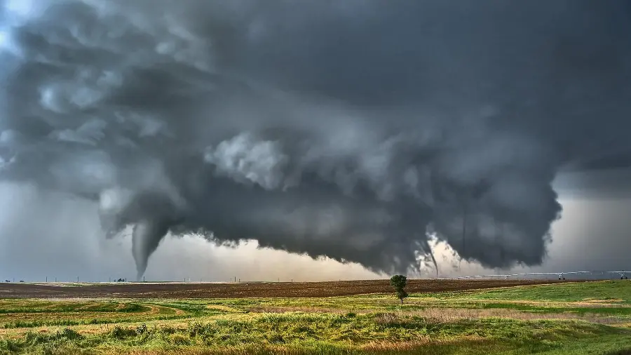 Spectacular gray tornado background on a green field