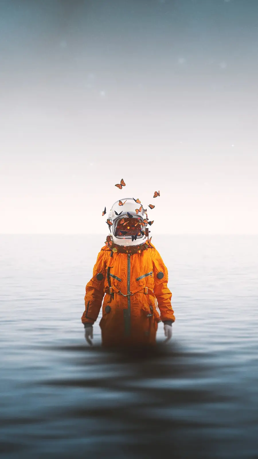 A very beautiful conceptual photo with an astronaut and orange butterflies in the sea water