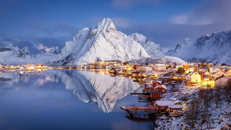 Attractive image of snowy and icy blue mountains with houses next to them