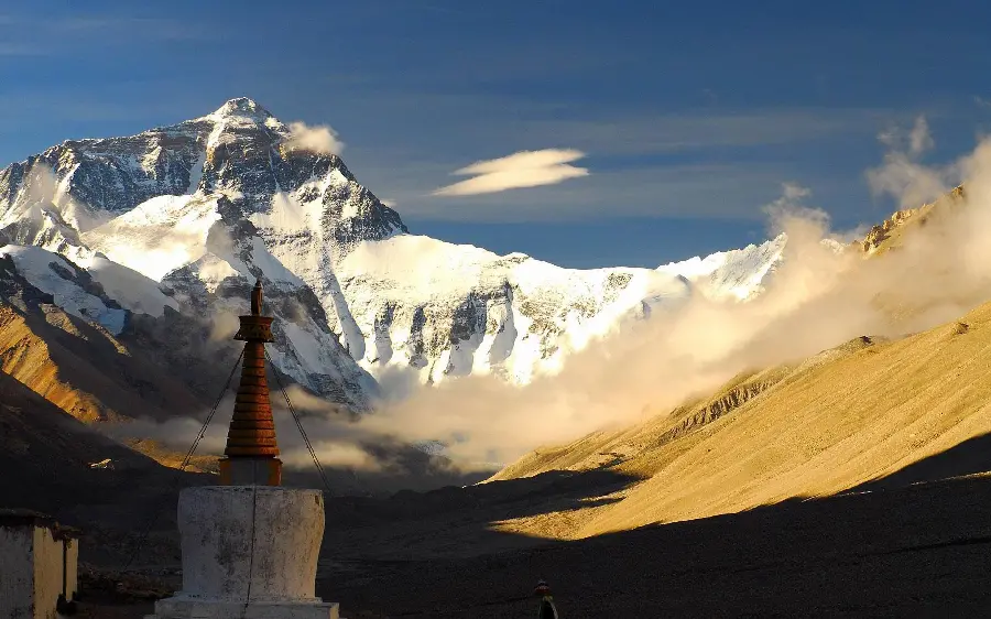 Picture of a small temple with a cement base in the snowy mountains of Tibet