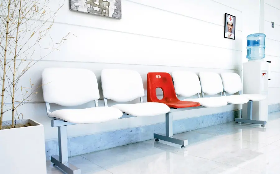 A very interesting picture of a special red chair in a hospital