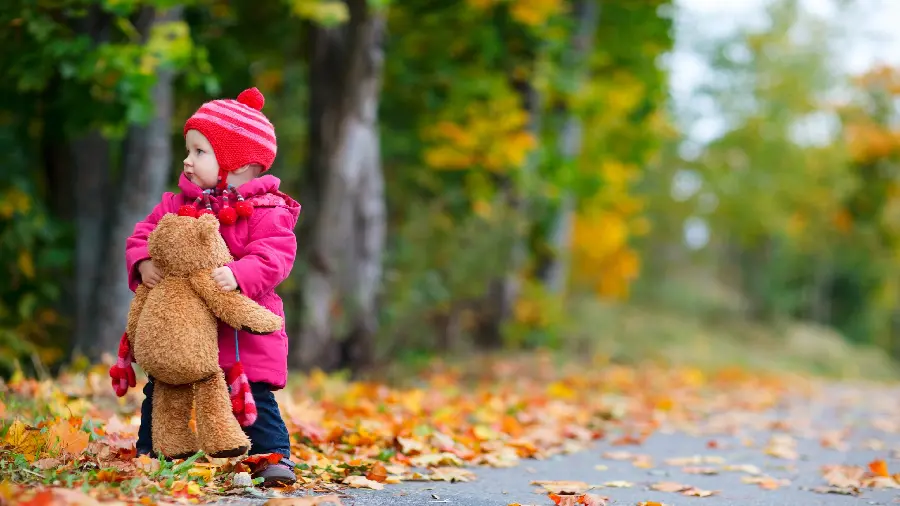 Background image of a little girl with her doll in the park