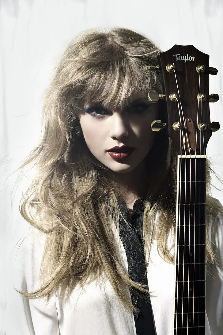 A charming wallpaper of Taylor Swift with her famous guitar