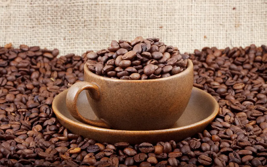 Artistic background photo of coffee beans in a cup for desktop