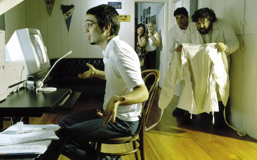 Image of a mental patient being arrested in an asylum behind a computer desk