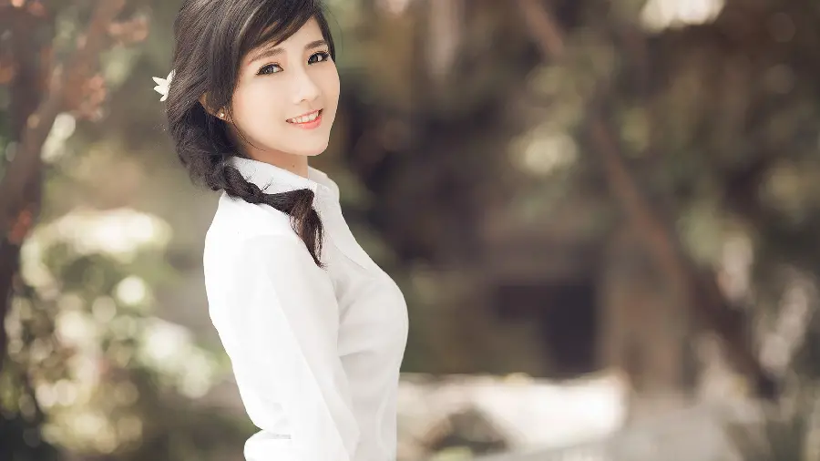 Photo of a beautiful Korean girl with black hair with a cute smile and a white shirt