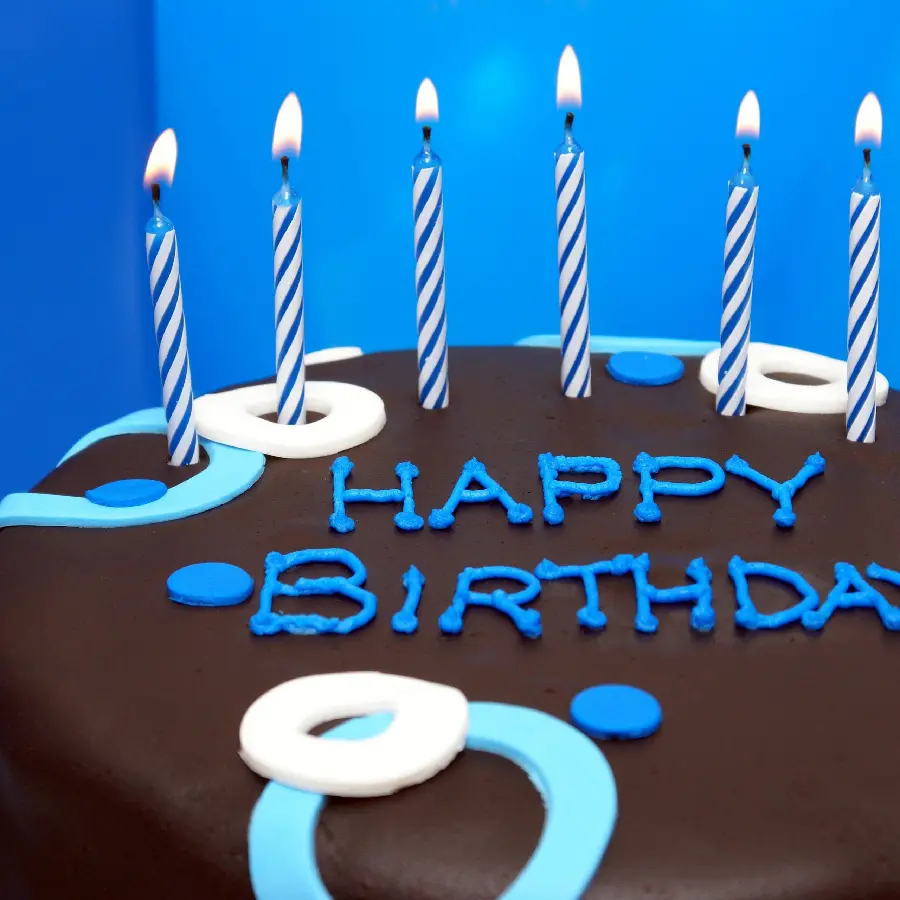 Chocolate birthday cake with blue candle decoration for boy profile 2023