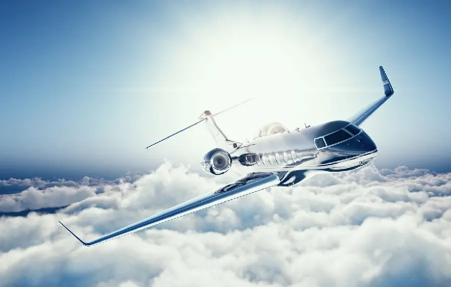 Photo of a private jet above the clouds