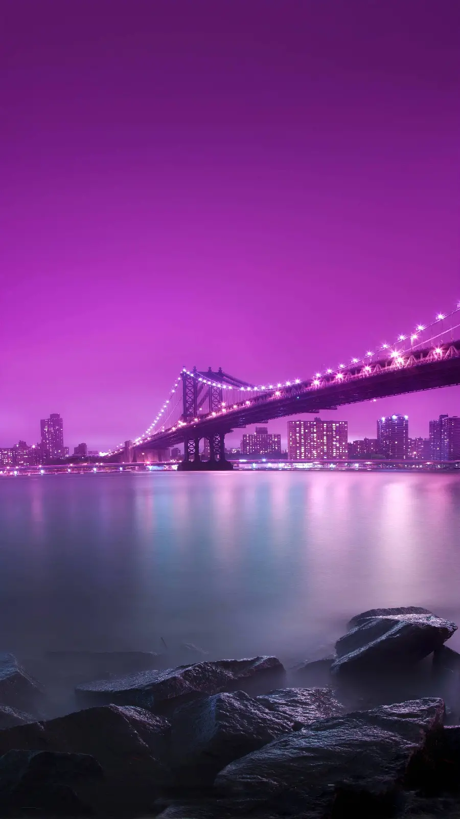 Dreamy image of a large bridge at night with a charming purple halo