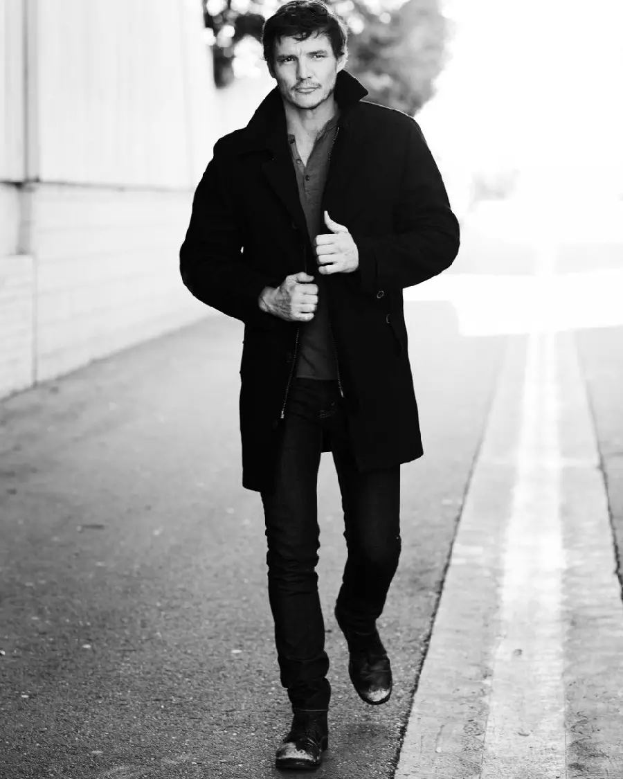A stylish old image of Pedro Pascal with a long black coat
