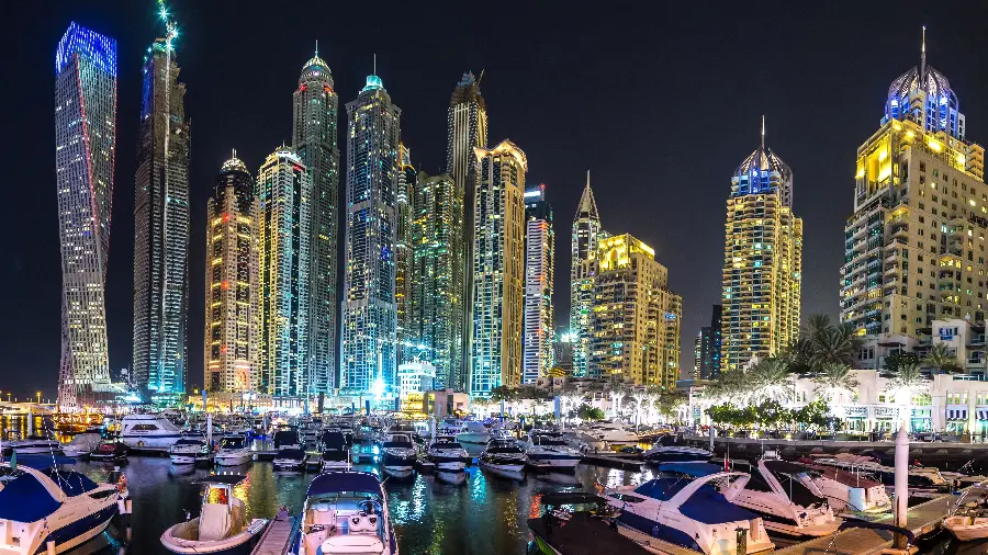 Photo of Dubai at night with beautiful lake and illuminated buildings 